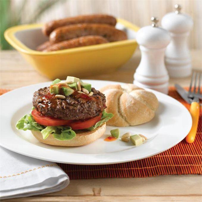 Beef burgers with a topping of avocado, sweet chilli sauce and toasted pine nuts