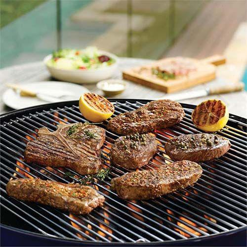 Barbecued t-bone steaks seasoned with herbs and green peppercorns