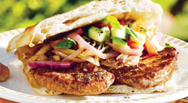 Barbecued steak sandwich with barbecued onion, cucumber, tomato and basil leaves